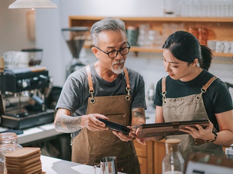 man and woman working at coffee shop