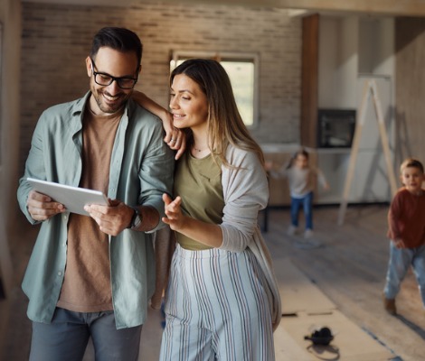 Happy parents using digital tablet during home renovations