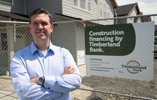Timberland Bank Commercial Loan Officer Joel Slovick stands in front of a construction site.